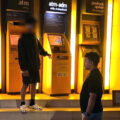 Man with a helmet busy taking out cash at an ATM led police on Monday to uncover a Chinese scam effort